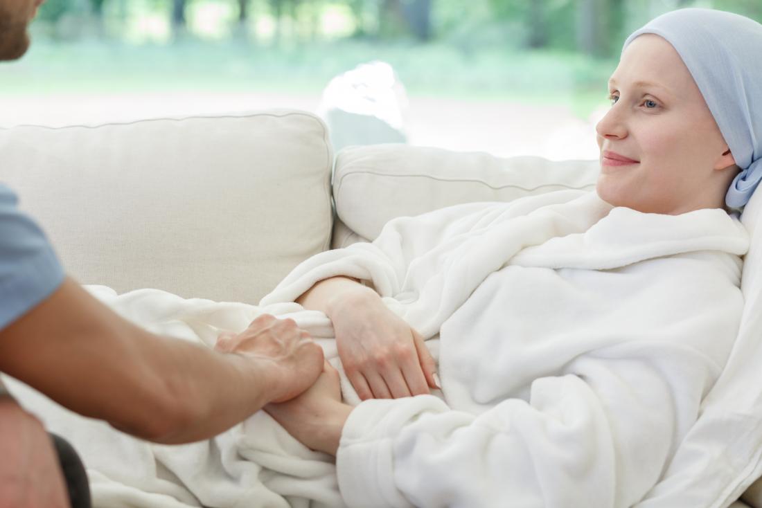 Breast cancer patient resting on sofa with partner.