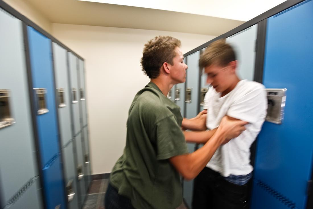 boy bullying another boy by lockers