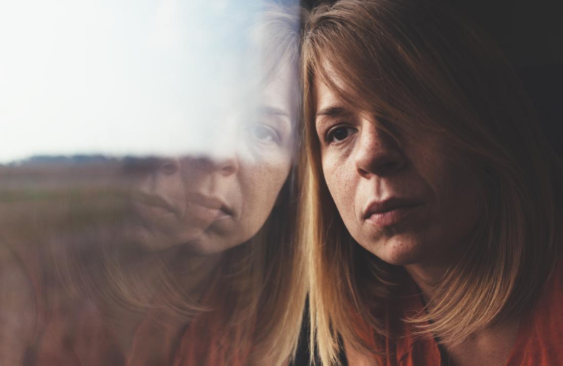a sad woman looking out of a window