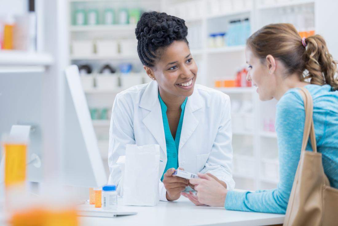 Pharmacist discussing different medicines with patient.