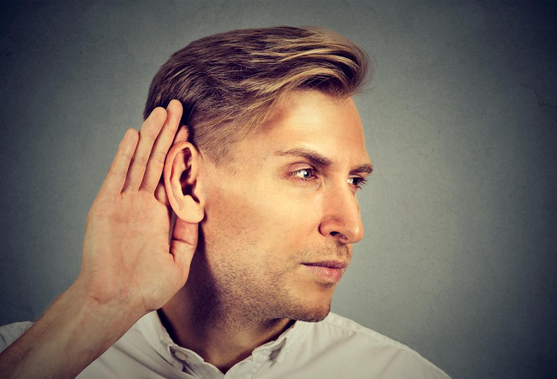 man cupping his ear