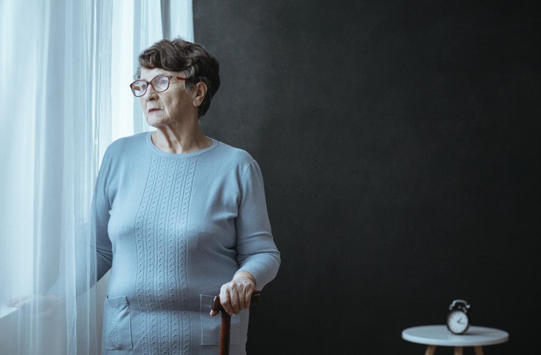 older lady with parkinsonsism looking out of a window