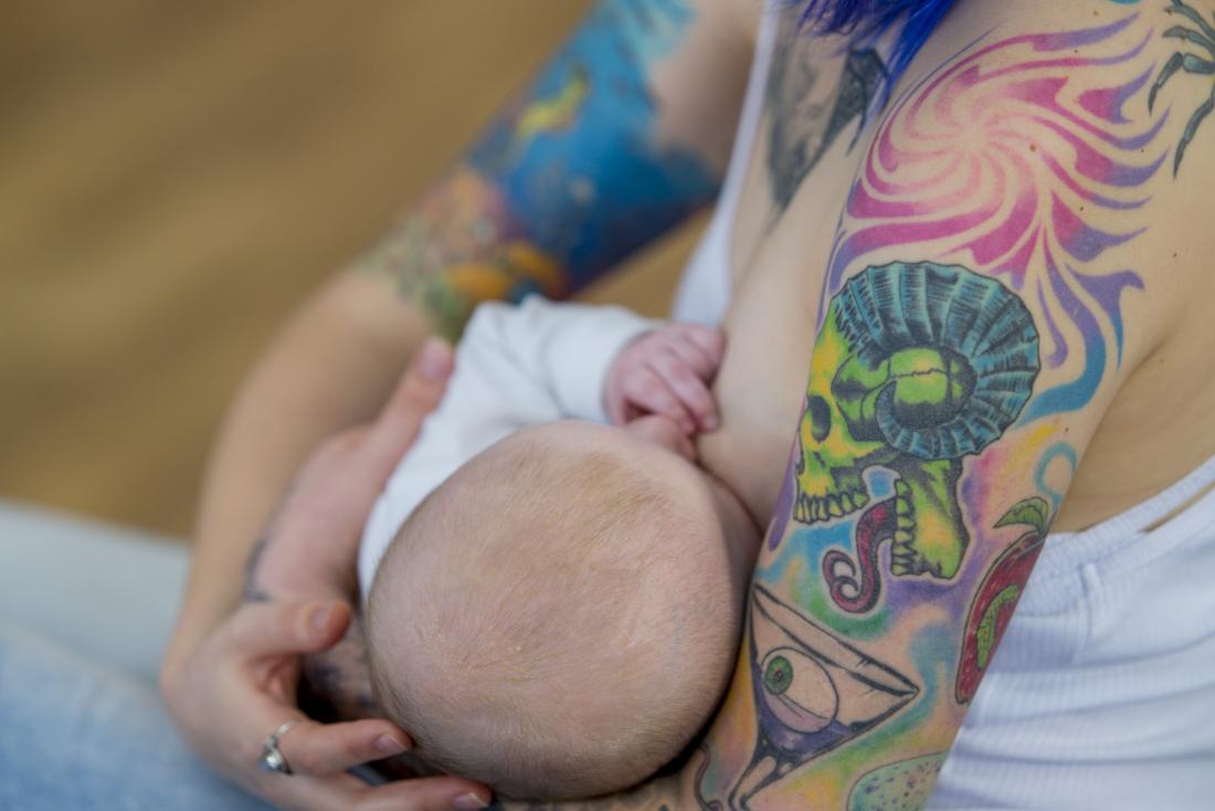 lady with tattoos breast feeding her baby