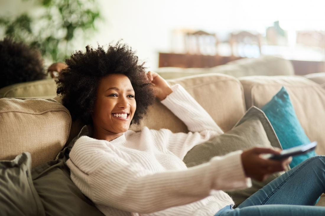 Comfortable woman relaxing on couch watching TV