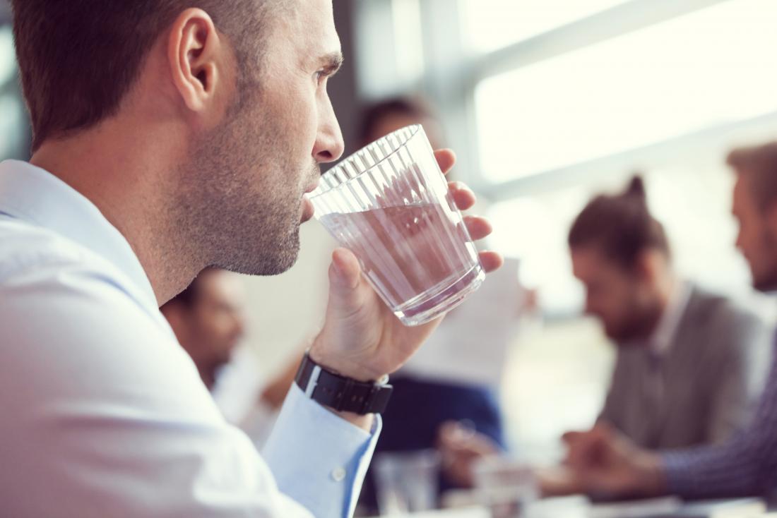 Man drinking water from glass.