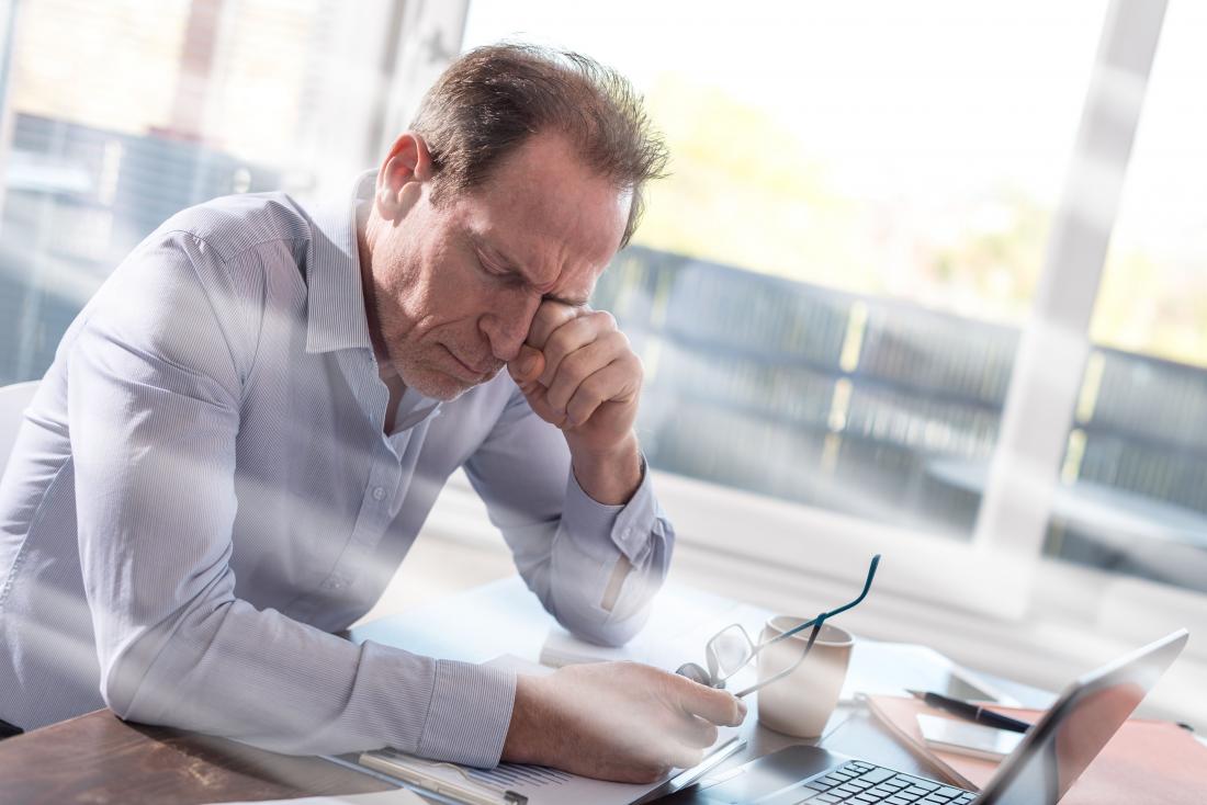 Tired businessman rubbing his eyes.
