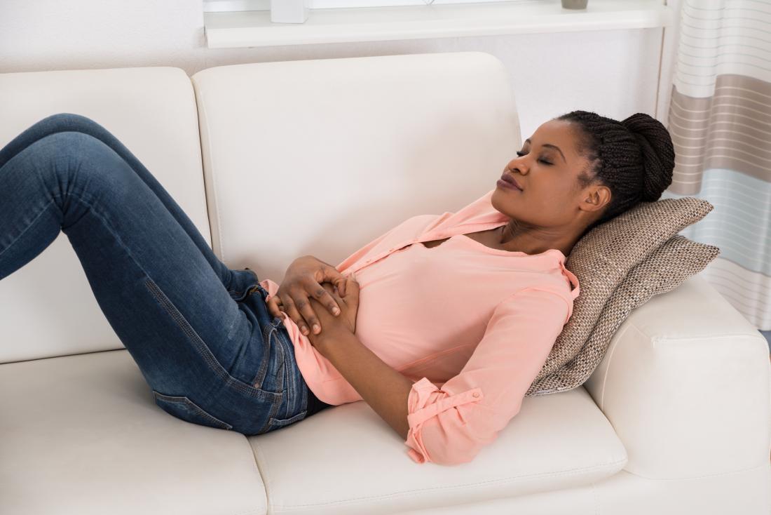 young woman lying on the sofa who wants to know how to get rid of nausea