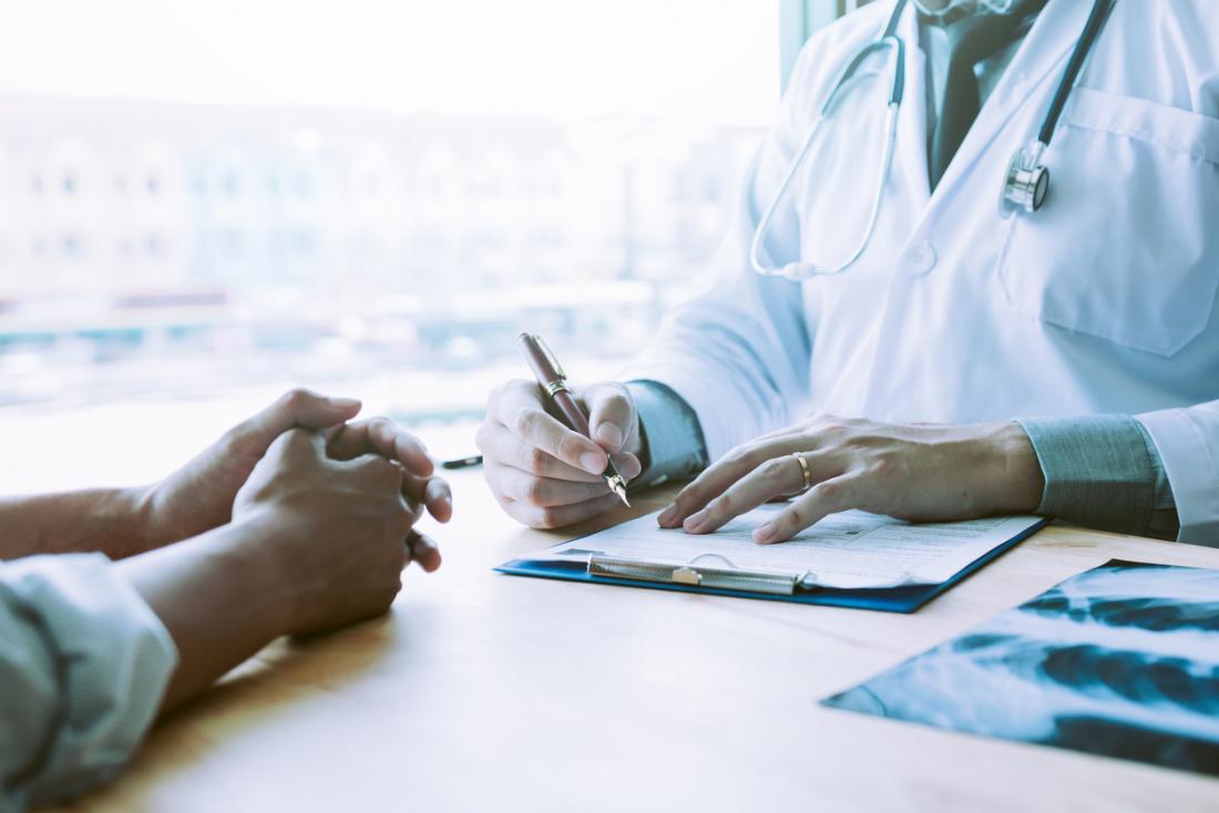 doctor writing notes with patient