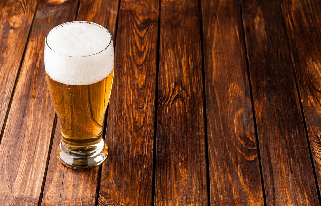 Beer in glass on wooden table.