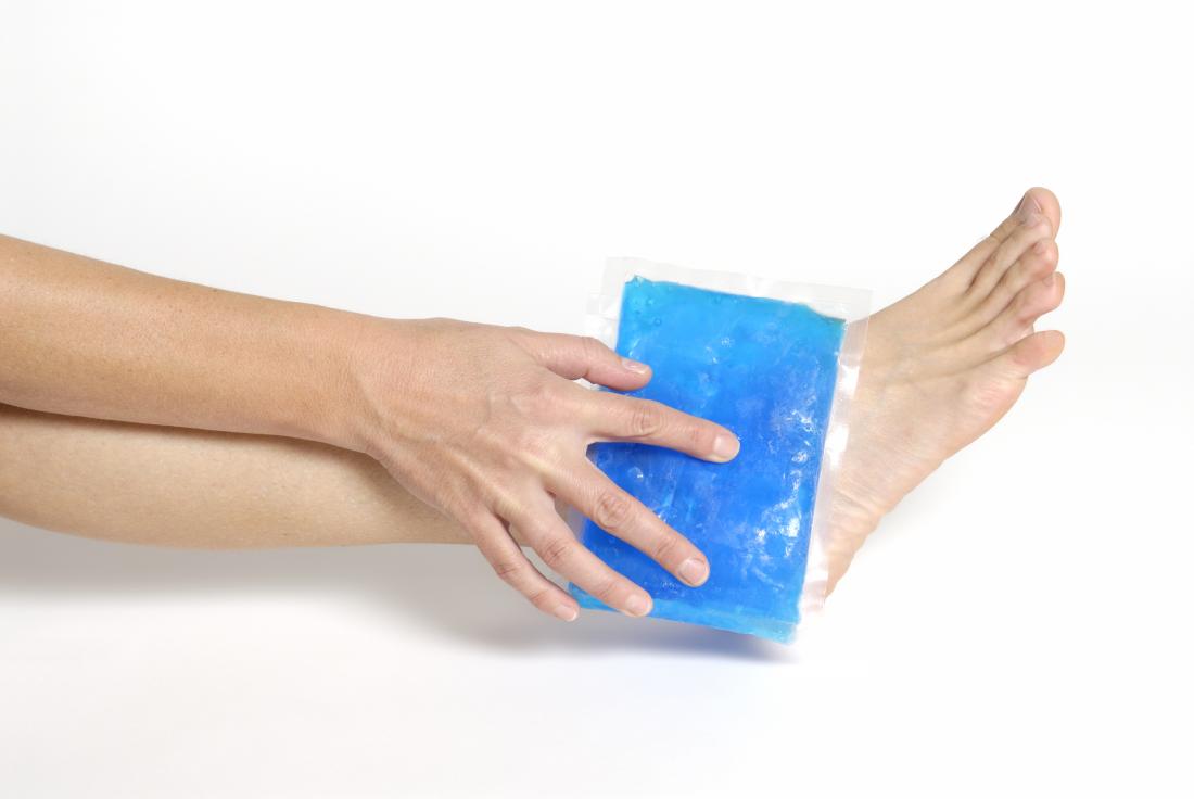 Person holding an icepack on their foot which is recommended first aid for broken foot symptoms