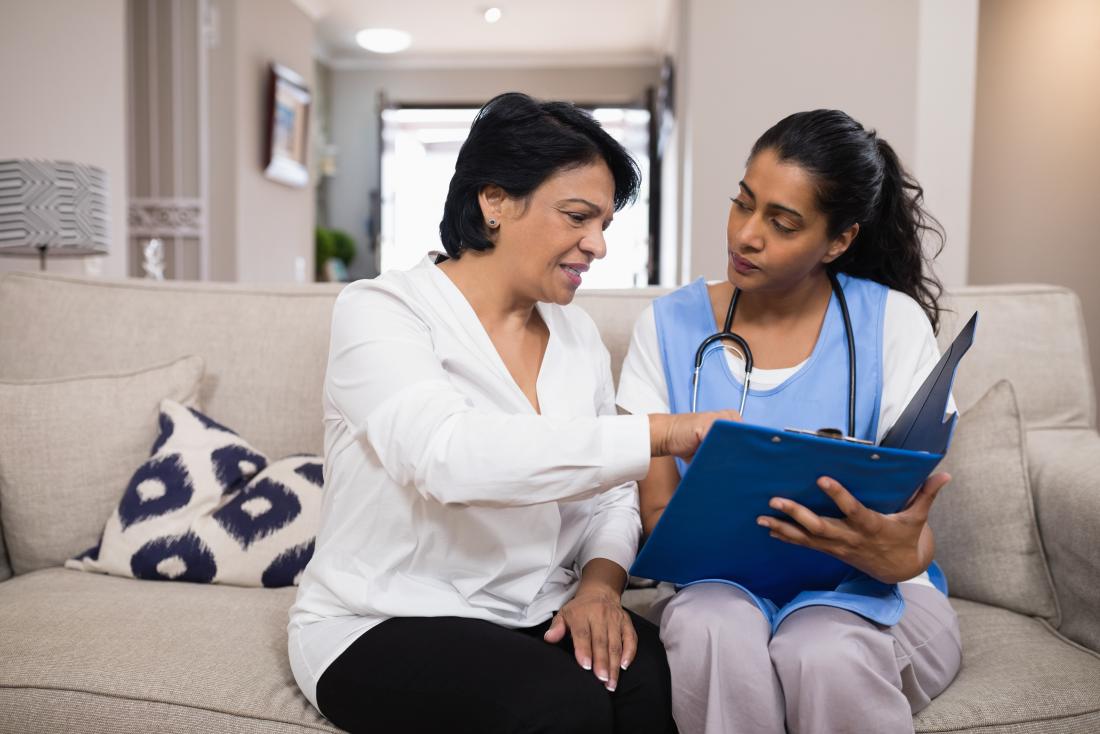 Doctor in patient's home discussing report.