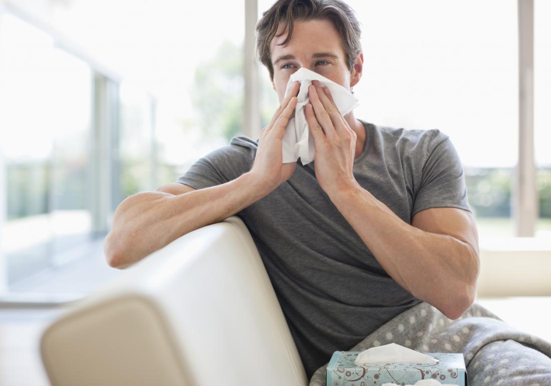 man with a cold blowing his nose