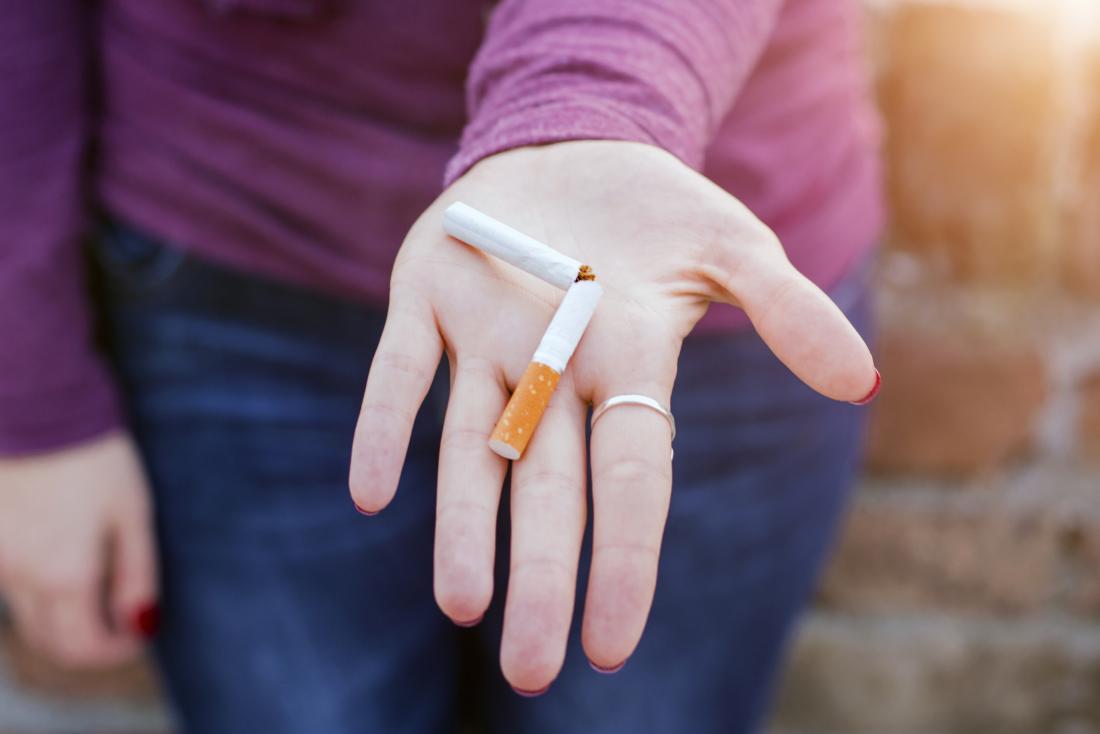 woman holding a broken cigarette in her hand
