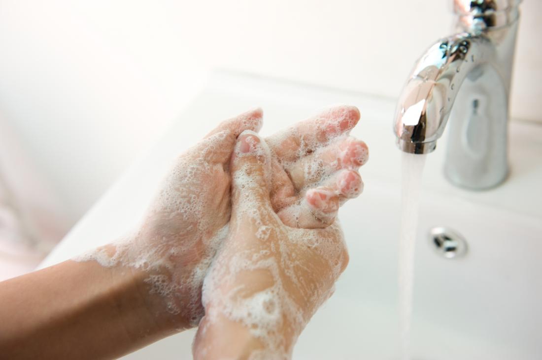 woman washing her hands with soap and water