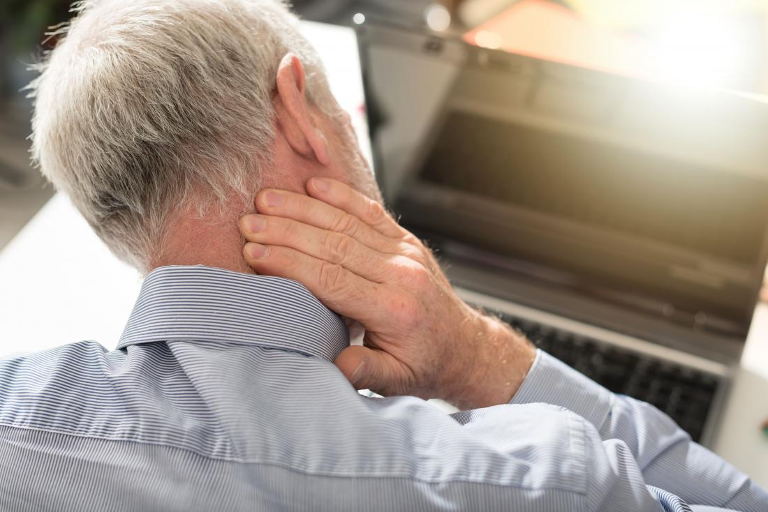 Man With Headache Pain At Back Of Head Rubbing Neck 