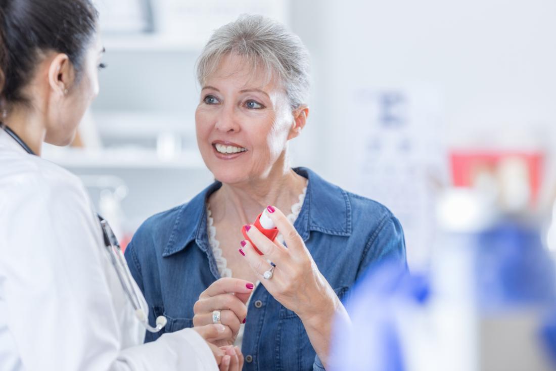 Doctor advising patient about inhaler.