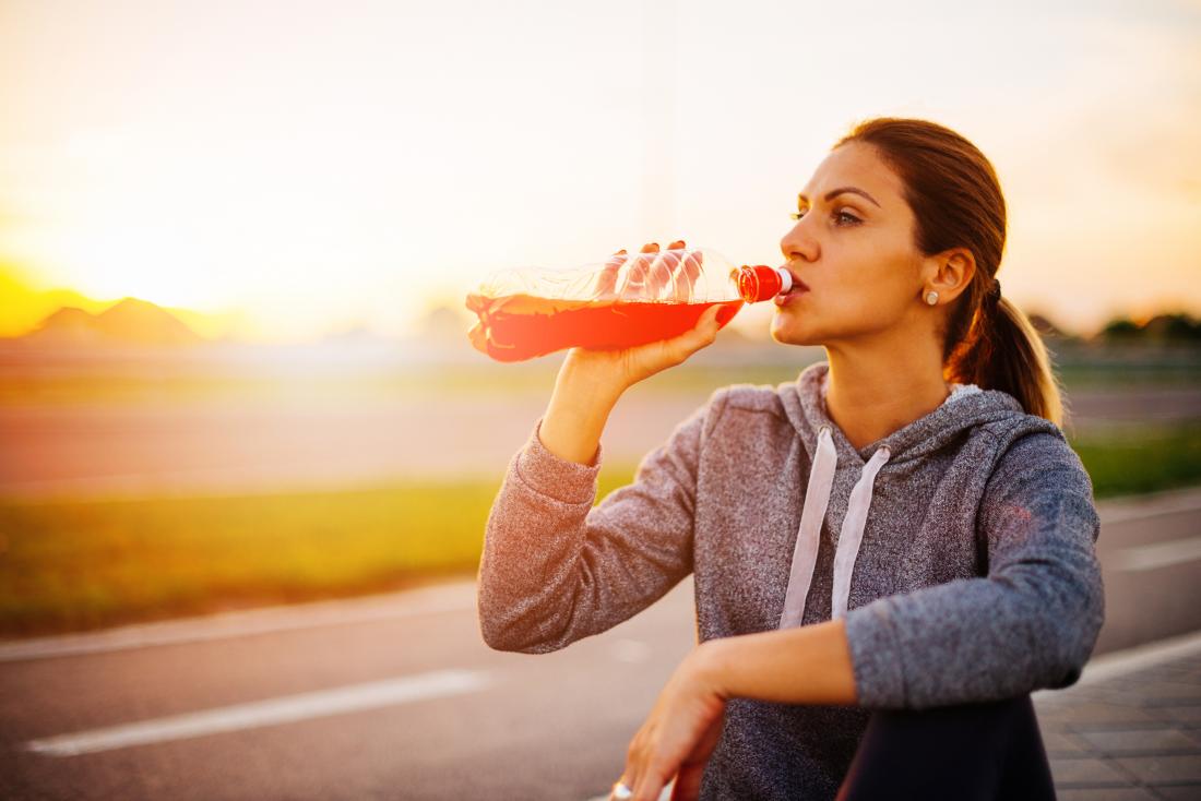 Woman drinking a sports drink after jogging