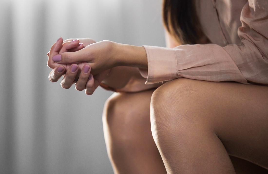 woman sat with hands together