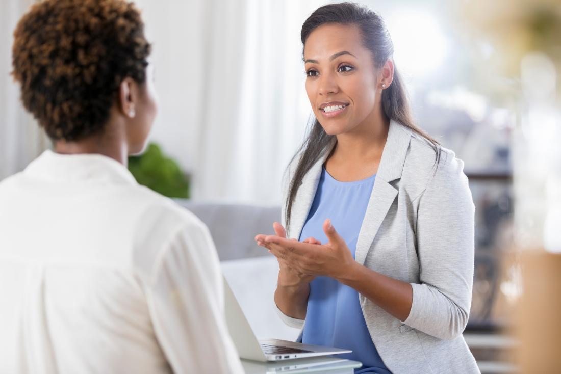 Female doctor speaking to female patient in neat modern office.