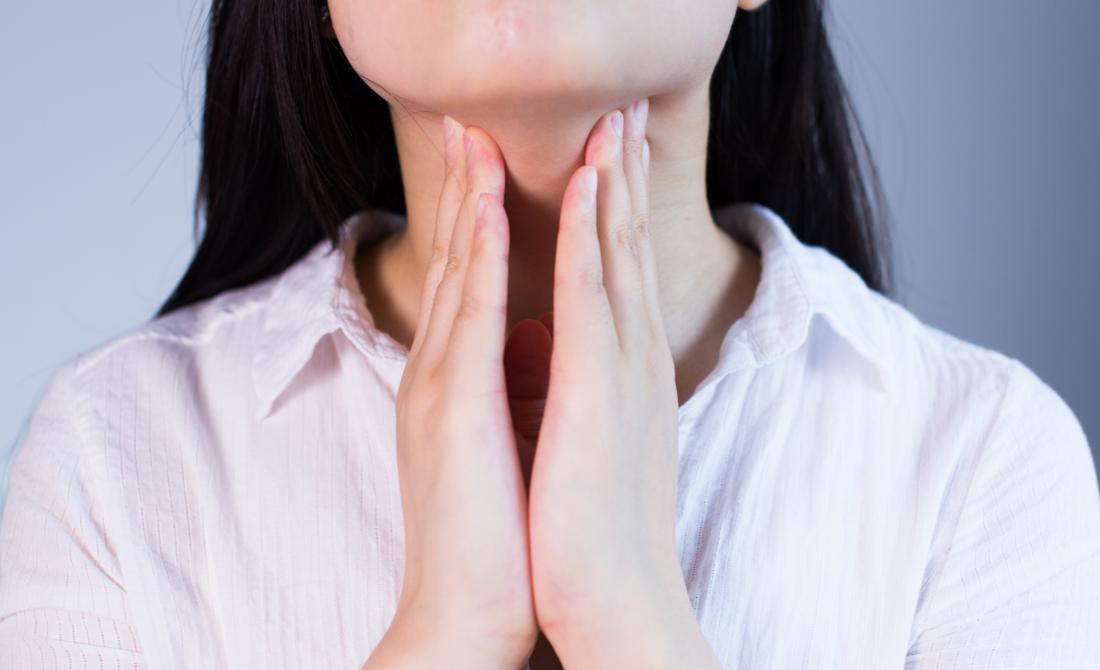 Woman feeling lymph nodes under chin for lump.