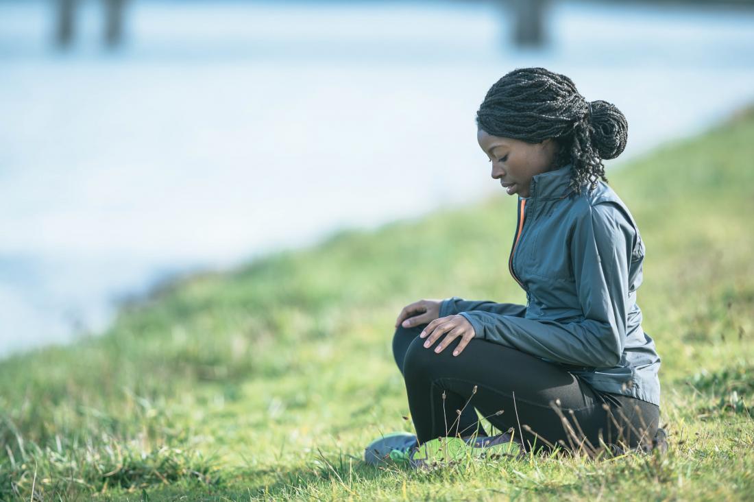 woman meditating on grass