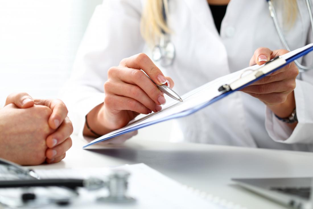 Doctor with a clipboard showing it to patient to discuss results.
