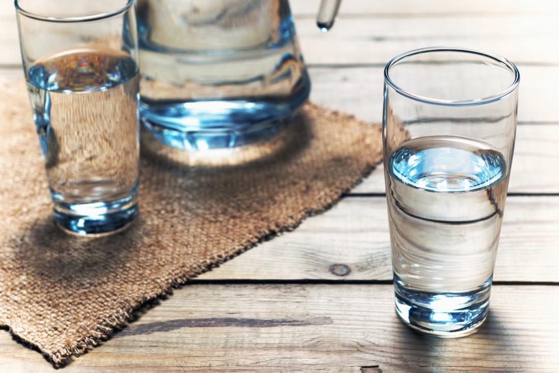 Glasses of water on wooden table.