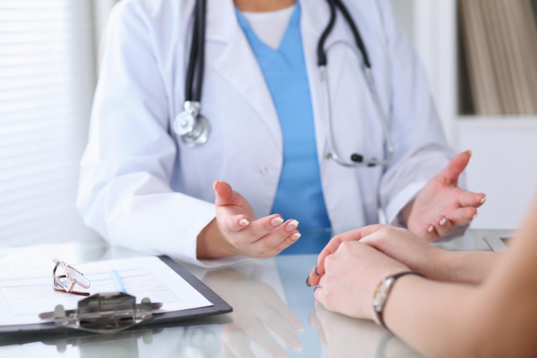 Female doctor's hands over desk in explanation to patient.