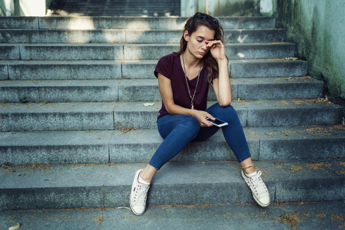 GIrl sat on steps looking sad with mild depression