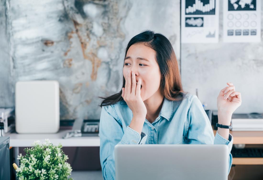 woman yawning at her computer