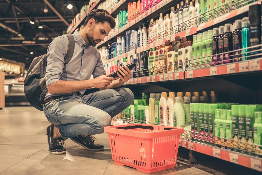 Man comparing cosmetic products in shop.