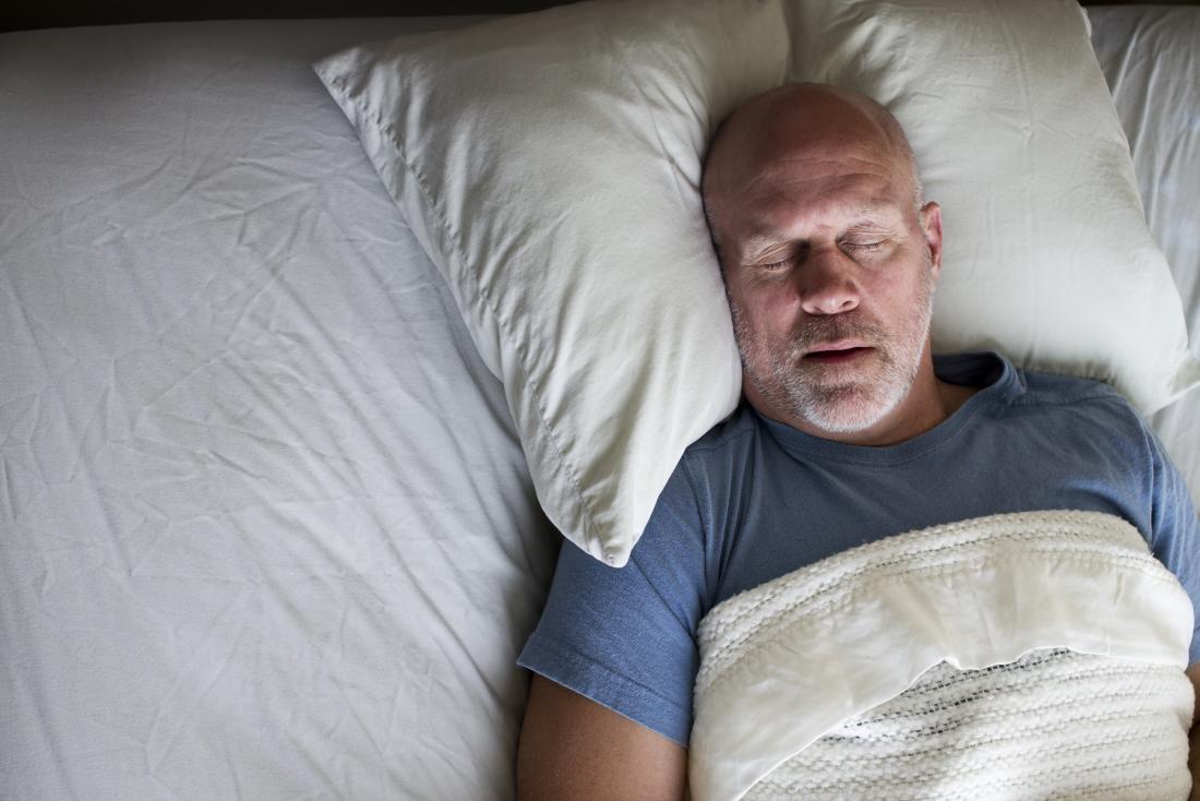 middle aged man asleep in bed