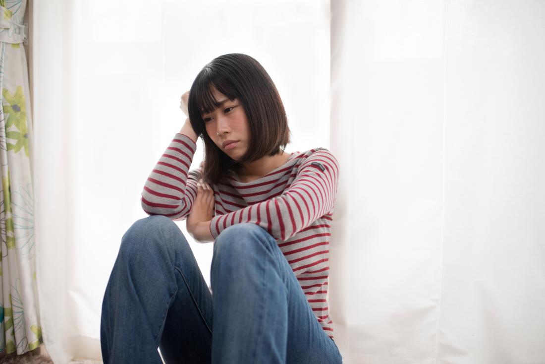 depressed woman sitting in a corner