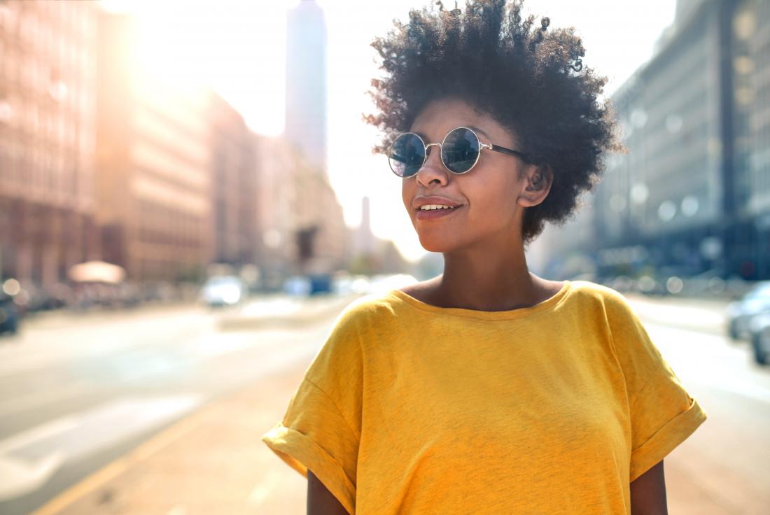 Woman outside in city wearing sunglasses.