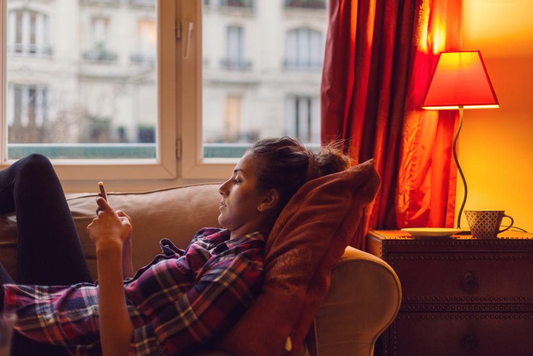 sedentary lifestyle shown by woman lying on couch.