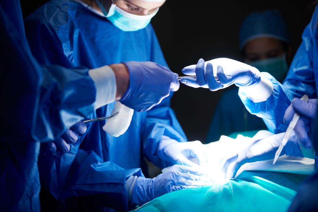 surgeons working in dark operating theatre