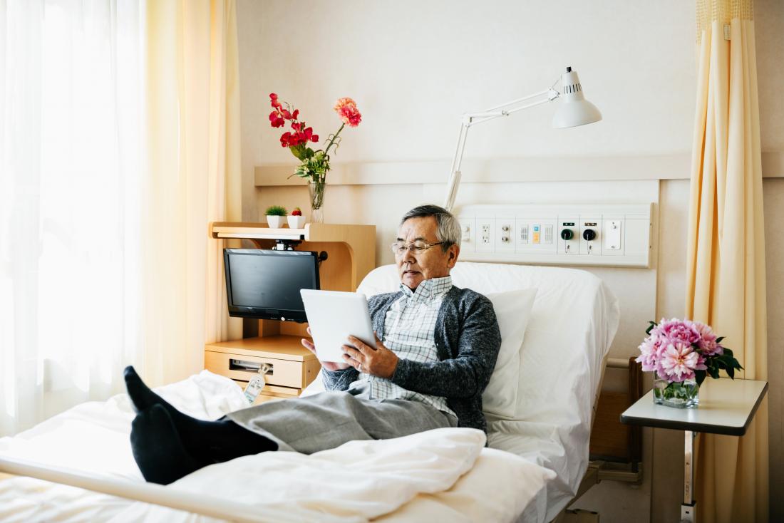 senior man reading in a hospital bed