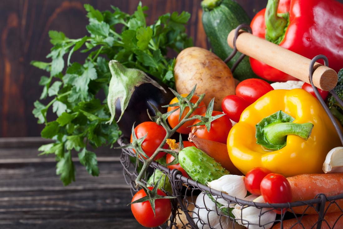 Basket of mostly nightshade vegetables including peppers, tomatoes, eggplant,potato