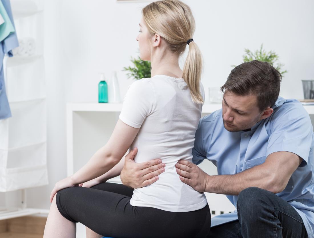 Woman suffering from hyperlordosis with a physical therapist