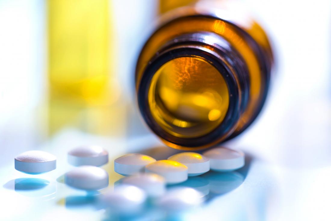 Antibiotics spilling out of medicine bottle.