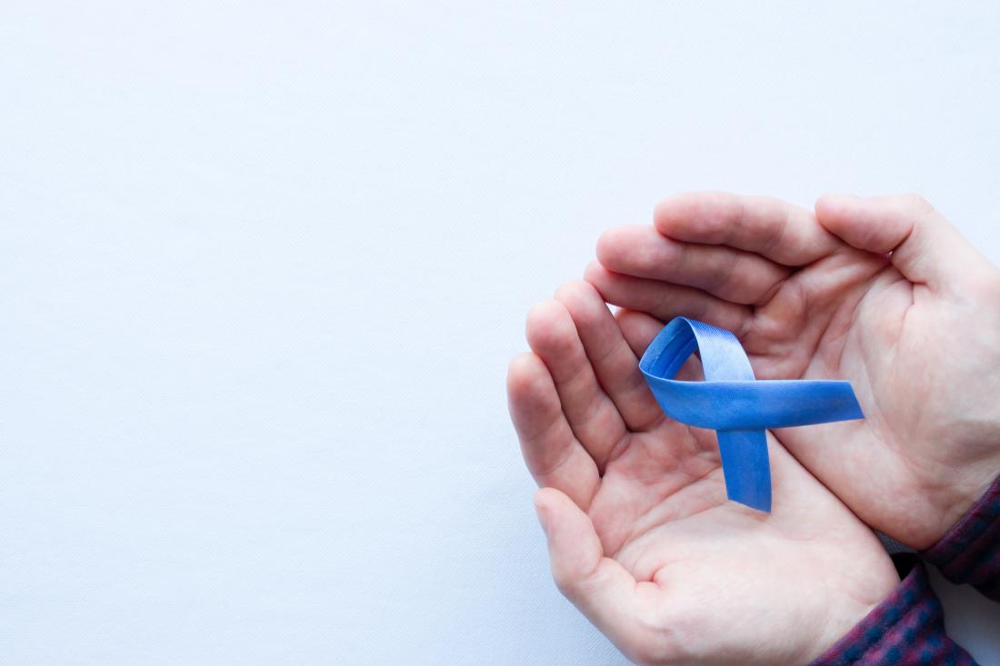 man holding blue ribbon