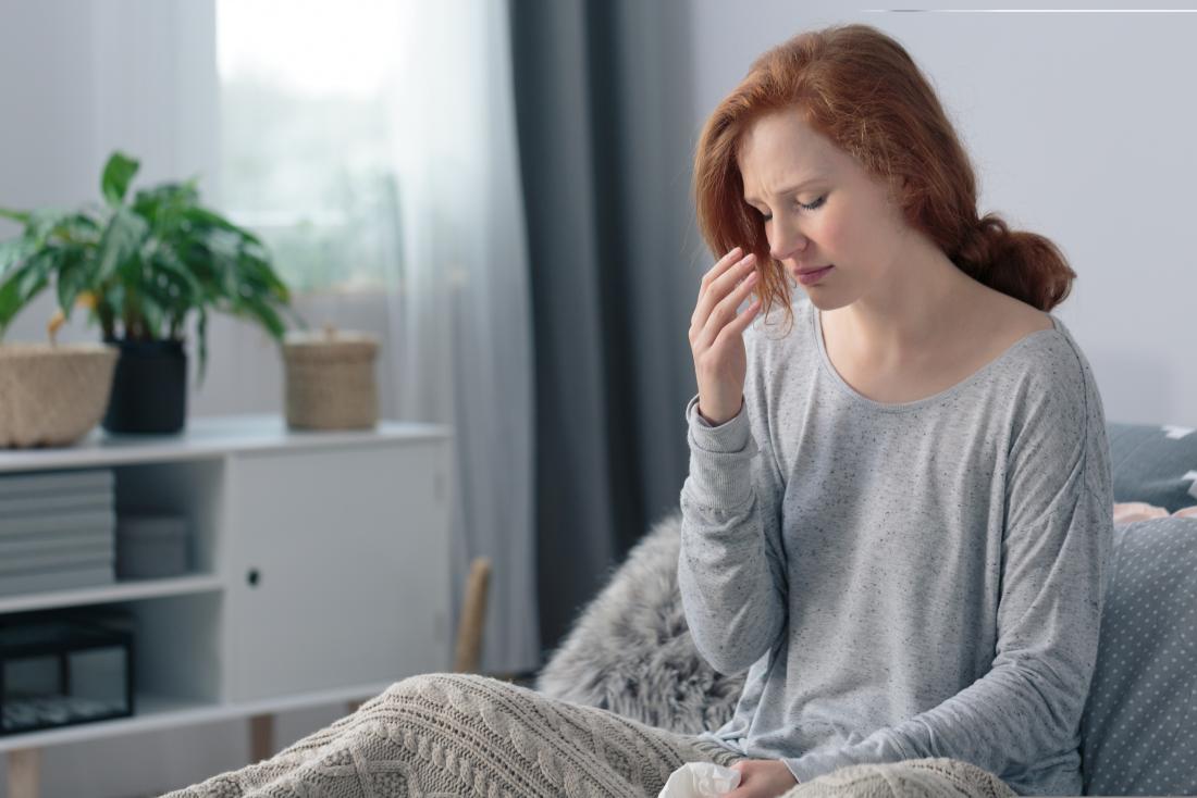 Woman under blanket unwell with sinusitis