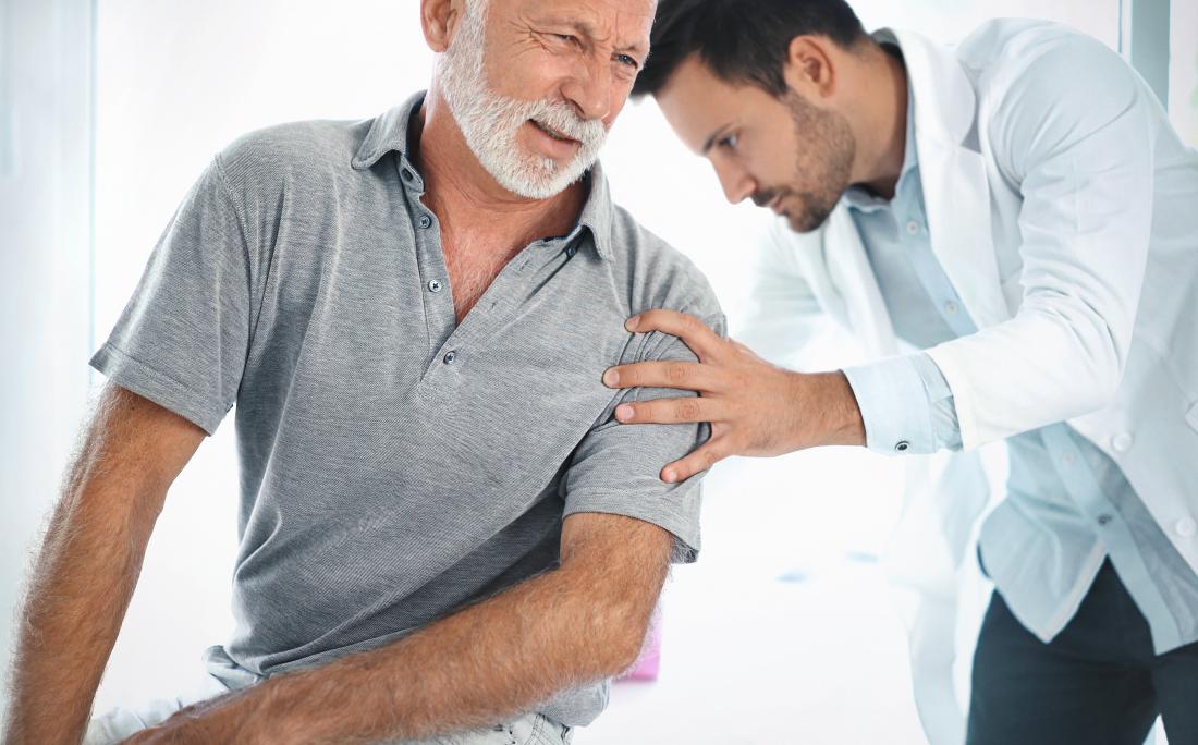 Doctor performing physical examination of older mans back