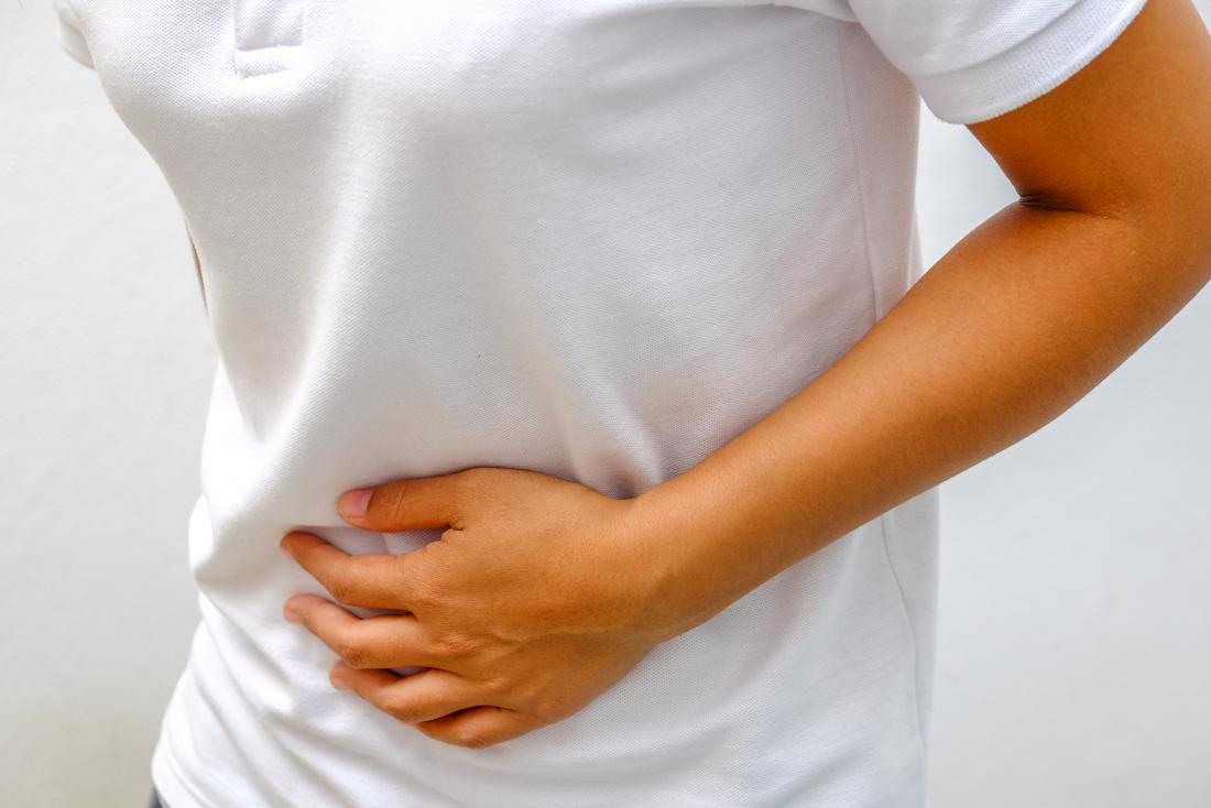 Stomach pain in person clutching stomach.
