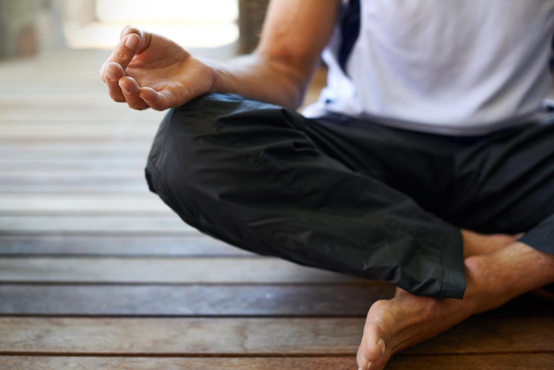 Person sitting cross-legged and meditating.