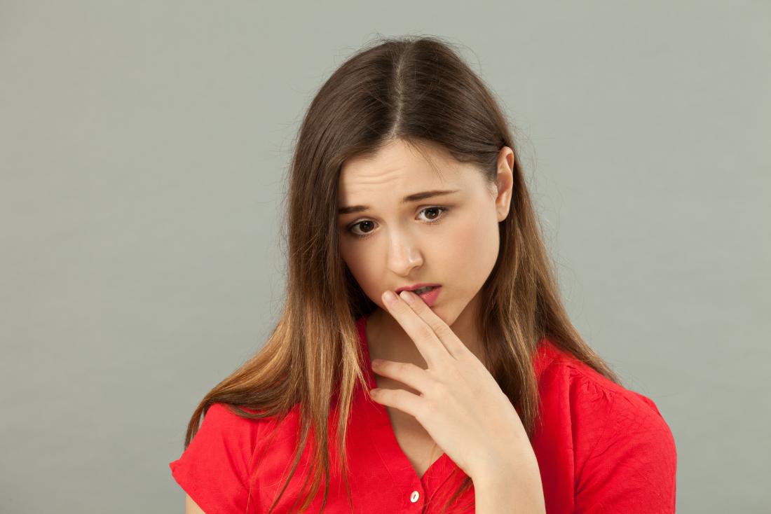 young woman with hand up to mouth