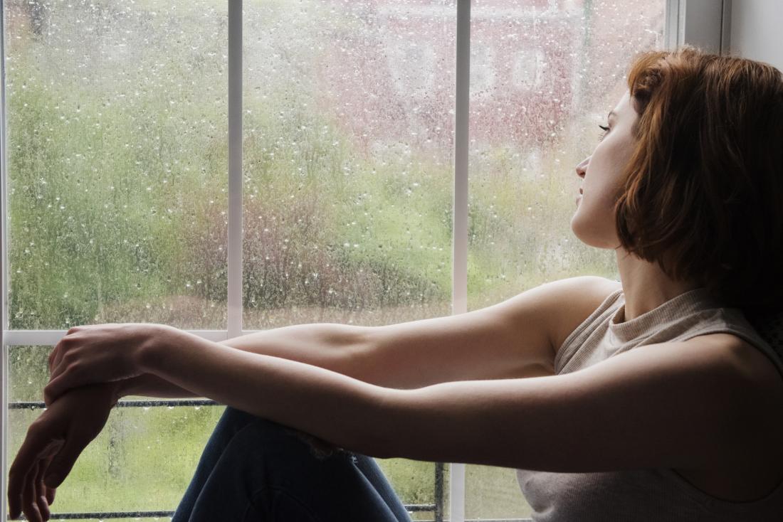Woman staring out of window due to catatonic depression