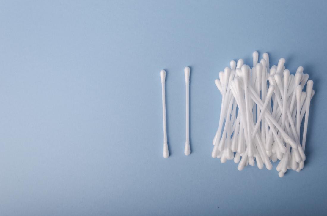 Cotton buds piled on blue background.