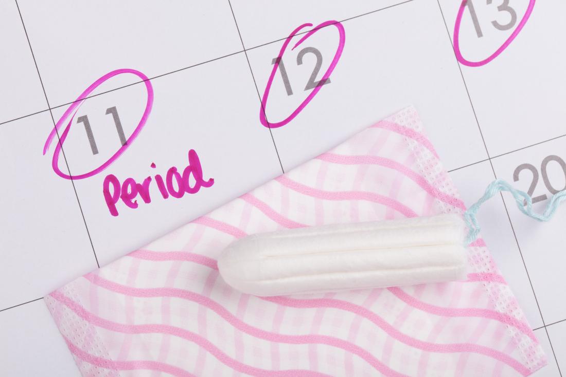 Period dates marked down on calendar next to tampon 