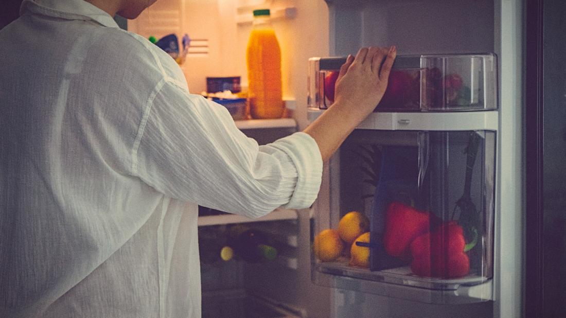woman looks in fridge